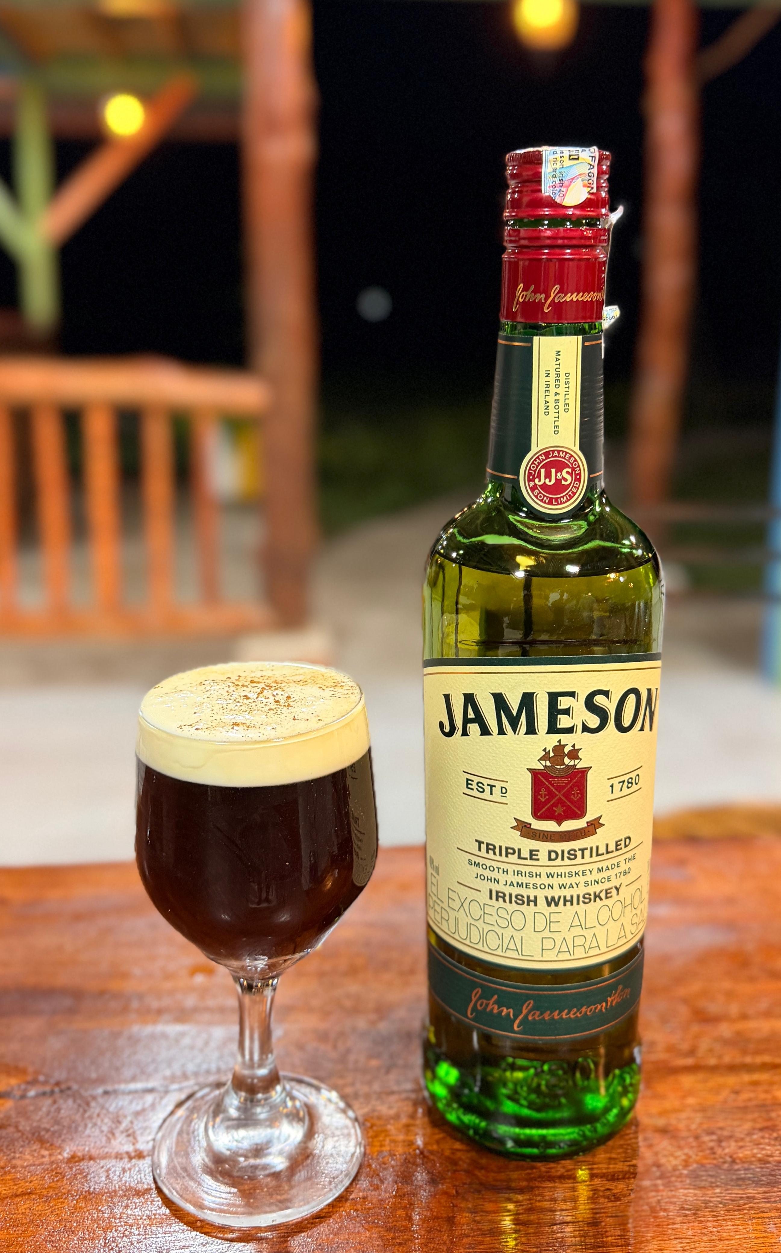 Café irlandés servido junto a una botella de whisky