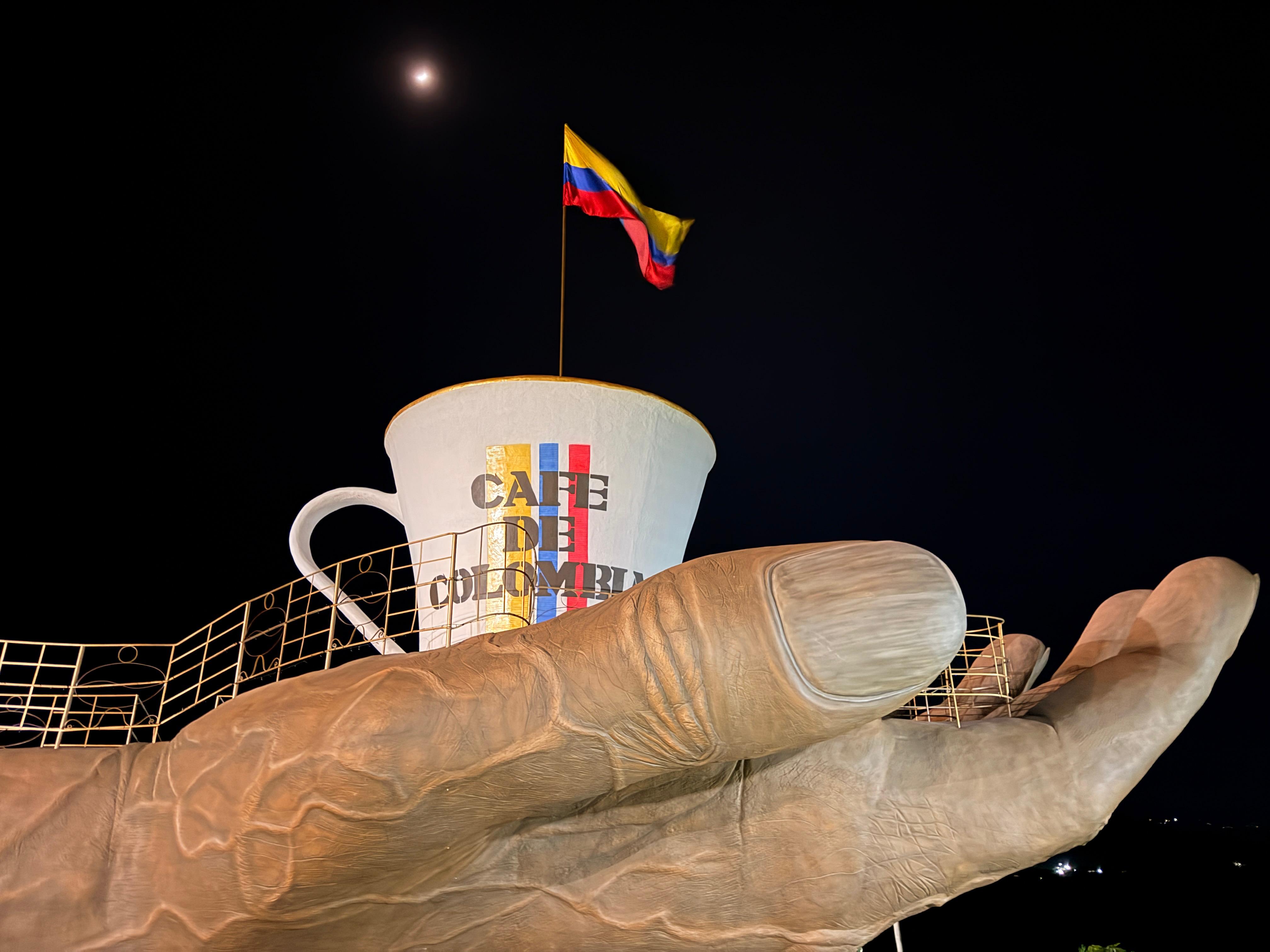 La Mano del Café de noche, con la luna y la bandera